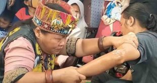 Ida Dayak yang lagi mengobadi warga. Foto : Medsos.