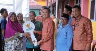 Rukesi, warga Puncak Sekuning, menerima kunci rumah dari Sekda Palembang Ratu Dewa, hasil bedah rumah, Rabu (7/6/2023). Foto : Kominfo Palembang.