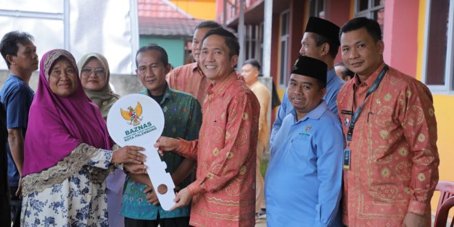 Rukesi, warga Puncak Sekuning, menerima kunci rumah dari Sekda Palembang Ratu Dewa, hasil bedah rumah, Rabu (7/6/2023). Foto : Kominfo Palembang.