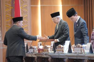 Juru bicara Fraksi Golkar Heru Prayogo menyerahkan berkas pandangan fraksi kepada Wagub Sumsel Mawardi Yahya. Foto Humas DPRD Sumsel.
