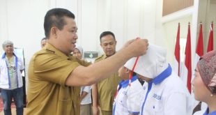 Asisten Administrasi Umum Setda Muba, Syaruddin menyematkan bed peserta lomba bertutur siswa SD/MIN, Senin (19/6/2023). Foto : Dinkominfo Muba.