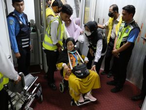 Salah seorang jemaah haji kloter 12 Debarkasi Palembang harus menggunakan kursi roda saat turun dari pesawat di bandara SMB 2, Kamis (20/7/2023). Foto : Sumselheadline/pitria