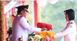 Bertindak sebagai inspektur upacara, Gubernur Sumsel Herman Deru menyerahkan sangsaka merah putih kepada pembawa baki Gesya Bilbina Adrein pada upacara HUT RI di Griya Agung, Palembang, Kamis (17/8/2023). Foto : Humas Pemprov Sumsel.