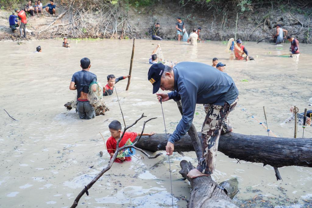 Tanpa ragu, Pj Bupati Muba Apriyadi, Minggu (3/9/2023) sore ikut nyebur dalam kegiatan bekarang di Lubuk Besak Sungai Care Desa Bandar Jaya Kecamatan Sekayu. Foto : Dinkominfo Muba.