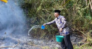 Dengan air dan alat seadanya, Pj Bupati Muba Apriyadi ikut memadamkan api yang membakar lahan, Minggu (3/9/2023). Foto : Dinkominfo Muba.