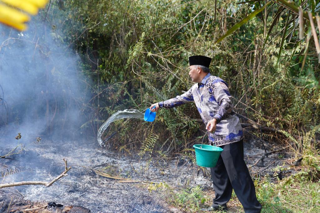Dengan air dan alat seadanya, Pj Bupati Muba Apriyadi ikut memadamkan api yang membakar lahan, Minggu (3/9/2023). Foto : Dinkominfo Muba.