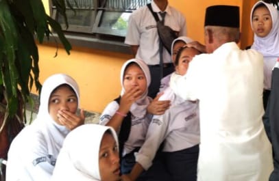 Seorang guru tampak mencoba menenangkan siswa SMAN 2 Palembang yang kesurupan, Senin (23/10/2023). Foto : Sumselheadline/Ela.