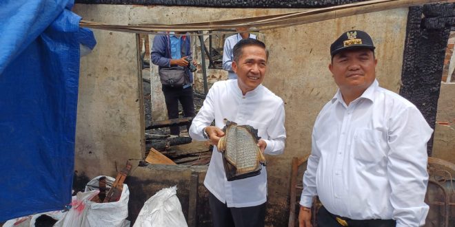 Pj Walikota Palembang, Ratu Dewa menunjukkan Alquran yang relatif utuh di puing-puing kebakaran rumah di 7 Ulu, Jumat (10/11/2023). Foto : Sumselheadline/Ela