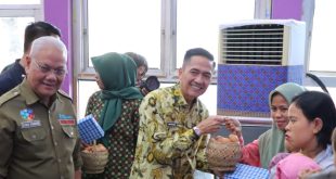 Pj Walikota Palembang, Ratu Dewa menyerahkan bantuan susu dan telur kepada ibu dan bayi guna mencegah stunting, Kamis (14/12/2023). Foto: Sumselheadline/Pitria.