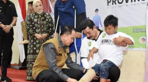 Pj Gubernur Sumsel, Agus Fatoni memasang alat bantu pada seorang disabilitas di Inderalaya, Kamis (21/12/2023). Foto: Humas Pemprov Sumsel.