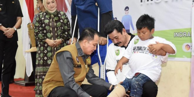 Pj Gubernur Sumsel, Agus Fatoni memasang alat bantu pada seorang disabilitas di Inderalaya, Kamis (21/12/2023). Foto: Humas Pemprov Sumsel.
