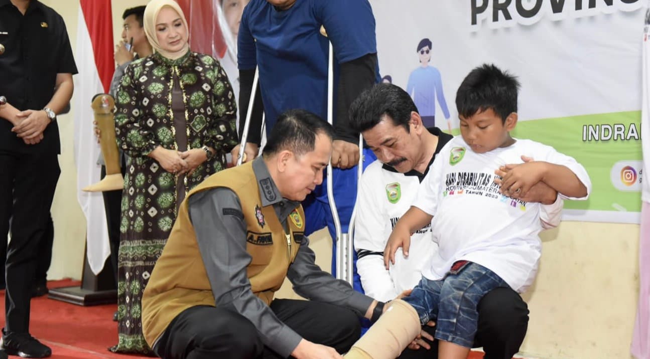 Pj Gubernur Sumsel, Agus Fatoni memasang alat bantu pada seorang disabilitas di Inderalaya, Kamis (21/12/2023). Foto: Humas Pemprov Sumsel.