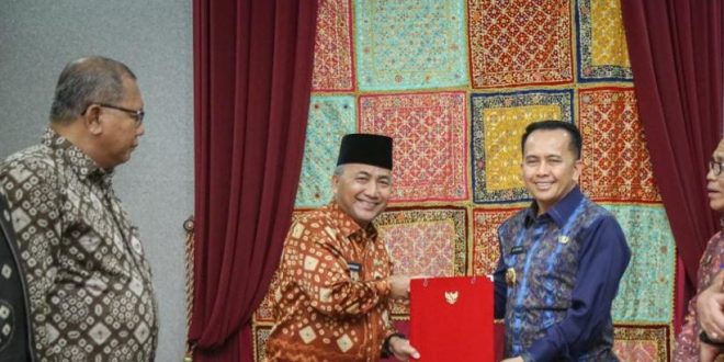 Pj Gubernur Sumsel Agus Fatoni menyerahkan SK tuan rumah Porprov 2025 kepada Pj Bupati Muba, Apriyadi, Kamis (14/12/2023). Foto: Dinkominfo Muba.