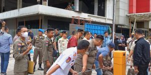 Sejumlah petugas gabungan merantai dan menyegel lahan parkir komplek Rajawali Palembang, Kamis (11/1/2024). Foto: Sumselheadline/Pitria.