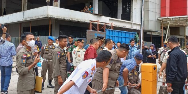 Sejumlah petugas gabungan merantai dan menyegel lahan parkir komplek Rajawali Palembang, Kamis (11/1/2024). Foto: Sumselheadline/Pitria.