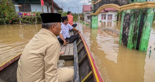 Menggunakan perahu, Pj Bupati Muba Apriyadi mengelilingi Desa Ulak Embacang Kecamatan Sanga Desa yang tenggelam akibat luapan Sungai Rawas, Rabu (17/1/2024). Foto: Dinkominfo Muba.