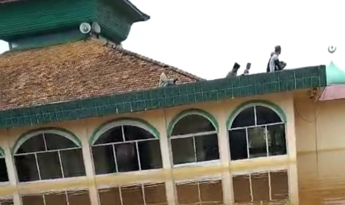 Banjir besar yang melanda Desa Ulak Embacang, Sanga Desa, Muba, membuat warga terpaksa sholat Jumat berjemaah di atas atap dak masjid. Foto: Screenshot video Hasan.