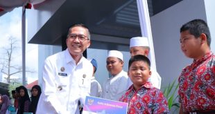 Secara simbolis seorang siswa SD dari panti sosial menerima kartu indonesia pintar dari Pj Walikota Palembang, Ratu Dewa, Rabu (31/1/2024). Foto: Sumselheadline/Pitria.
