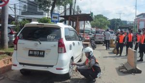 Petugas Dishub Palembang mengempisi ban mobil yang parkir sembarangan, Selasa (16/1/2024). Foto: Sumselheadline/Pitria.