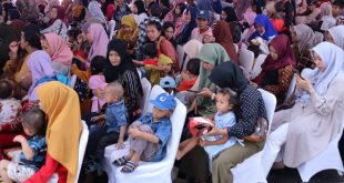 Sejumlah ibu-ibu dan anak yang mendapat paket makanan dan minuman bergizi dari Pemkot Palembang, Jumat (26/1/2024). Foto: Sumselheadline/Pitria.