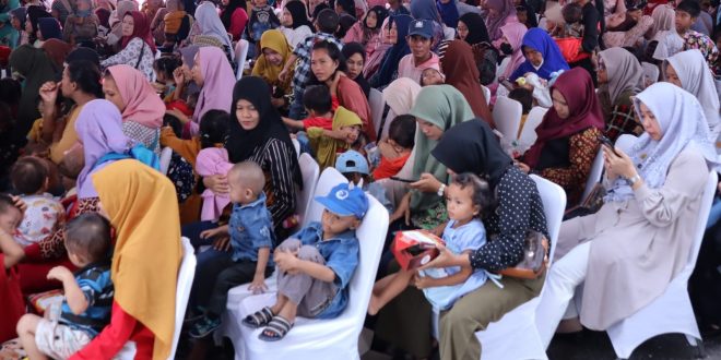 Sejumlah ibu-ibu dan anak yang mendapat paket makanan dan minuman bergizi dari Pemkot Palembang, Jumat (26/1/2024). Foto: Sumselheadline/Pitria.