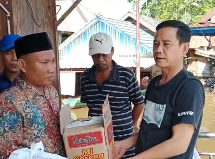 Ketum HKB Ulbamas Palembang, Nasrullah menyerahkan secara simbolis paket bantuan korban banjir kepada Kades Ulak Embacang, Nur'aidin Hasanuddin, Minggu (21/1//2024). Foto: Dok HGB Ulbamas.