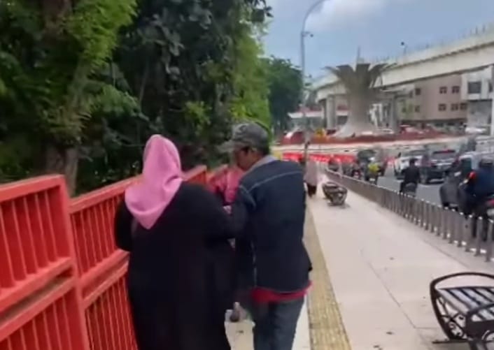 Seoang pria memaksa seorang wisatawan di atas Jembatan Ampera Palembang, untuk memberikan uang, Sabtu (13/1/2024). Foto: screenshot medsos.