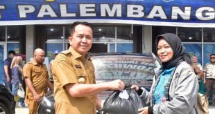 Pj Gubernur Sumsel, Agus Fatoni memberikan sembako pada warga yang taat pajak saat di Samsat Wilayah Palembang III. Foto: Humas Pemprov Sumsel.