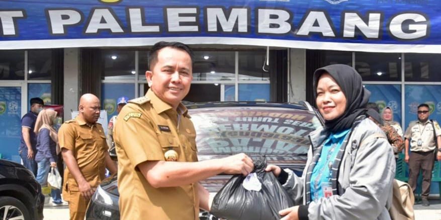 Pj Gubernur Sumsel, Agus Fatoni memberikan sembako pada warga yang taat pajak saat di Samsat Wilayah Palembang III. Foto: Humas Pemprov Sumsel.