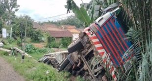 Sebuah truk trailer bermuatan paku bumi, terguling di pinggir jalan Desa Pulau Harapan, Banyuasin, Senin (5/2/2024). Foto: Tribunsumsel.com.