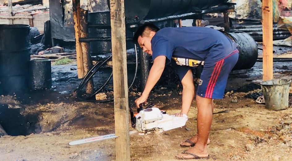 Seorang warga membongkar tungku penyulingan minyak ilegal di Sanga Desa, Muba, Kamis (21/3/2024). Foto: Dok Polsek Sanga Desa.
