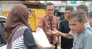 Petugas dari Ditintelkam Polda Sumsel membagikan sembako kepada warga, Jumat (15/3/2024). Foto: Sumselheadline/Fer.