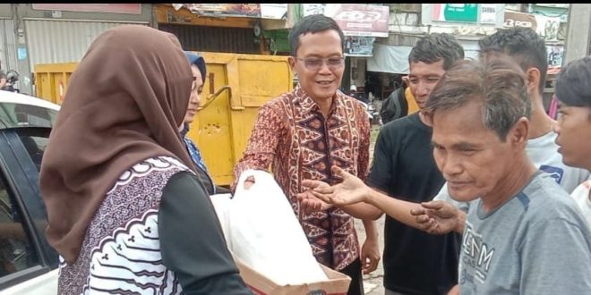 Petugas dari Ditintelkam Polda Sumsel membagikan sembako kepada warga, Jumat (15/3/2024). Foto: Sumselheadline/Fer.