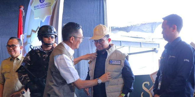 Pj Walikota Palembang, Ratu Dewa memasang rompi pada pejabat BI Palembang dalam rangka launching Program Bank Indonesia (BI) 'Kegiatan Susur Sungai' melalui Semarak Rupiah Ramadhan dan Berkah Idul Fitri (SERAMBI) 2024 di River Side, Benteng Kuto Besak Palembang, Selasa (26/3/2024). Foto: Kominfo Palembang.