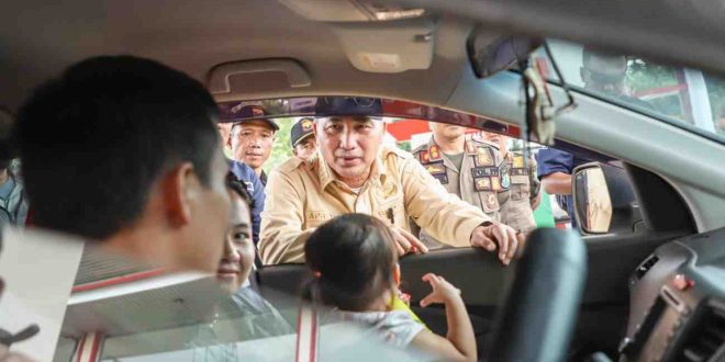 Pj Bupati Muba, Apriyadi tampak berbincang dengan pemudik yang melintas, seraya mengimbau untuk berhati-hati di jalan, Minggu (7/4/2024). Foto: Kominfo Muba.