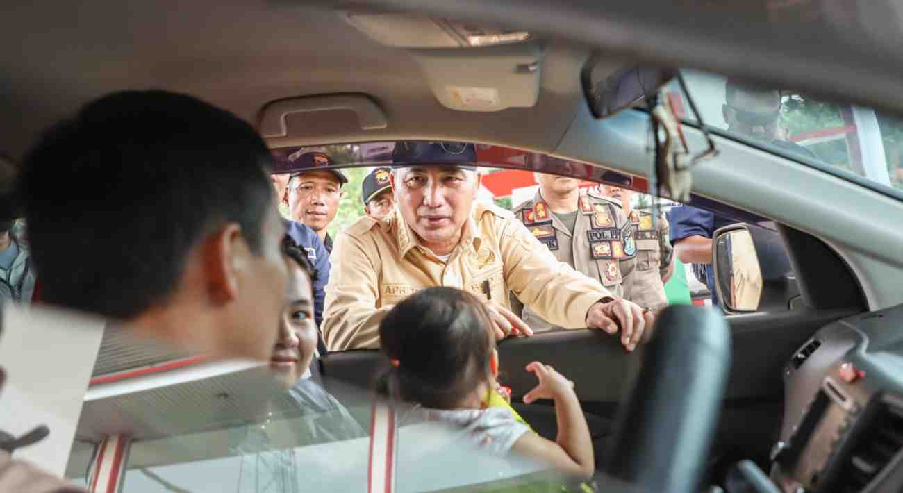 Pj Bupati Muba, Apriyadi tampak berbincang dengan pemudik yang melintas, seraya mengimbau untuk berhati-hati di jalan, Minggu (7/4/2024). Foto: Kominfo Muba.