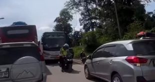 Tampak seorang polisi memaksa sopir memundurkan kendaraan yang menerobos jalur berlawanan, sehingga menjadi penyebab macet makin parah, Sabtu (6/4/2024) lalu. Foto: screenshot medsos.