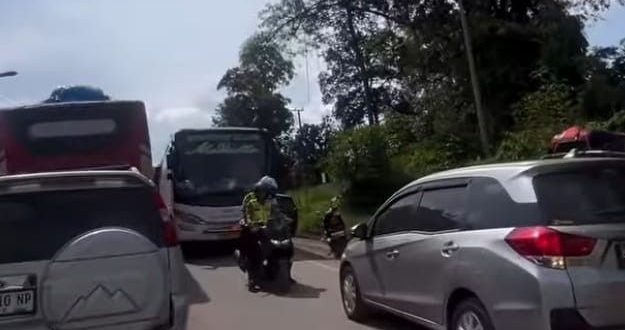 Tampak seorang polisi memaksa sopir memundurkan kendaraan yang menerobos jalur berlawanan, sehingga menjadi penyebab macet makin parah, Sabtu (6/4/2024) lalu. Foto: screenshot medsos.