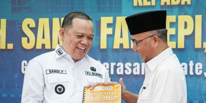 Apriyadi menyerahkan buku memori serah terima jabatan kepada Pj Bupati Muba yang baru, Sandi Fahlepi, Rabu (24/4/2024). Foto: Kominfo Muba.