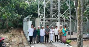 Warga Babat Supat foto dengan latar salah satu tower baru yang dipasang PT Telkomsel, atas program Pj Bupati Muba, Apriadi, Jumat (19/4/2024). Foto; Kominfo Muba.