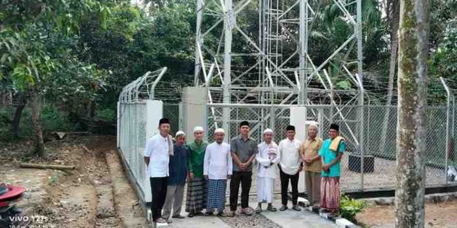 Warga Babat Supat foto dengan latar salah satu tower baru yang dipasang PT Telkomsel, atas program Pj Bupati Muba, Apriadi, Jumat (19/4/2024). Foto; Kominfo Muba.