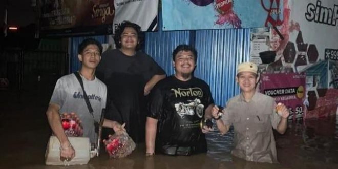 Warga Baturaja yang berjaga di seputar rumahnya yang terendam, Selasa (7/5/2024) malam. Foto: screenshot medsos.