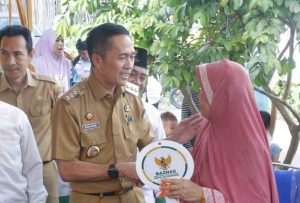 Pj Walikota Palembang, Ratu Dewa secara simbolis menyerahkan kunci rumah hasil Bedah Rumah kepada Suryatina di Kelurahan Karang Anyar Kecamatan Gandus,Selasa (14/5/2024). Foto: Kominfo Palembang.