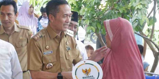 Pj Walikota Palembang, Ratu Dewa secara simbolis menyerahkan kunci rumah hasil Bedah Rumah kepada Suryatina di Kelurahan Karang Anyar Kecamatan Gandus,Selasa (14/5/2024). Foto: Kominfo Palembang.