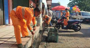 Para petugas DLH dan pedagang Pasar Perjuangan Sekayu gototng royong membersihkan saluran air, Sabtu (18/5/2024). Foto: Kominfo Muba.