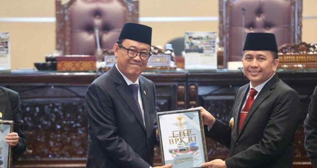 Anggota V BPK RI, Ahmadi Noor Supit menyerahkan pelakat WTP kepada Pj Gubernur Sumsel, Agus Fatoni pada sidang paripuran DPRD Sumsel, Senin (13/5/2024). Foto:Humas Pemprov Sumsel.