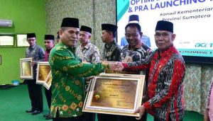Kepala Badan Litbang dan Diklat Kementerian Agama RI, Suyitno menyerahkan anugera keterbukaan informasi publik pada sejumlah Unit Tingkat Kankemenag Kab/Kota se-Provinsi Sumatera Selatan, Rabu (8/5/2024). Foto: Dok Kemenag Sumsel.