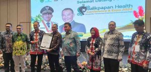 Kabid P2P Dinas Kesehatan Muba, Ucu Arunsang SKM MKes saat menerima penghargaan dari Asosiasi Dinas Kesehatan di Balik Papan. Foto: Dok Dinas Kesehatan MUba.
