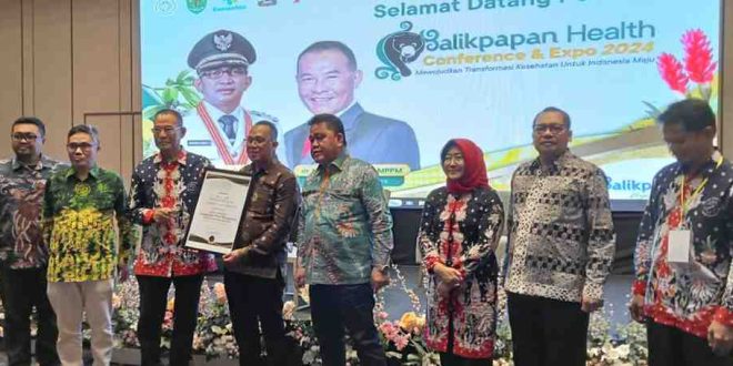 Kabid P2P Dinas Kesehatan Muba, Ucu Arunsang SKM MKes saat menerima penghargaan dari Asosiasi Dinas Kesehatan di Balik Papan. Foto: Dok Dinas Kesehatan MUba.