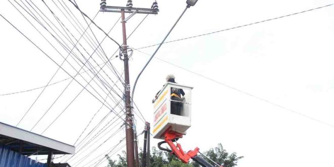 Seorang petugas edang memang lampu jalan di Gandus, Palembang, Senin (27/5/2024). Foto: Sumselheadline/Pitria.
